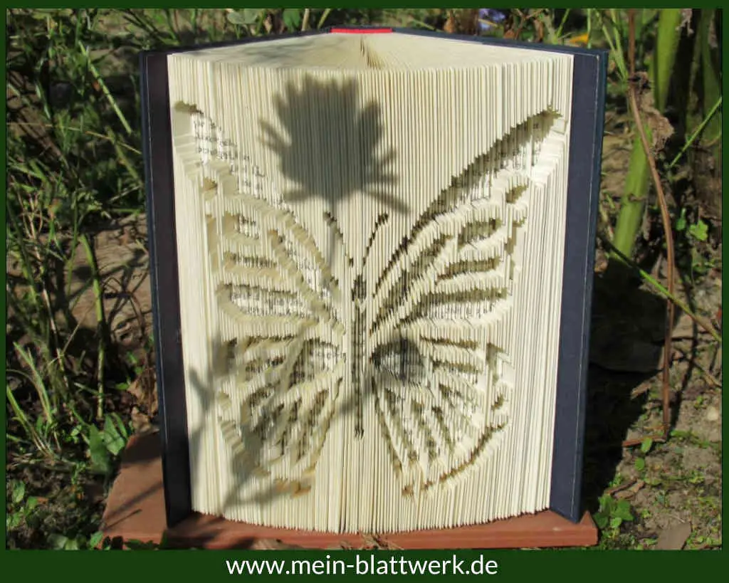 Einen Schmetterling in ein altes Buch falten. Deko aus Büchern mit einer kostenlosen Vorlage basteln.