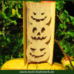 Basteln zu Halloween. Geschnitzten Kürbis in ein Buch falten.