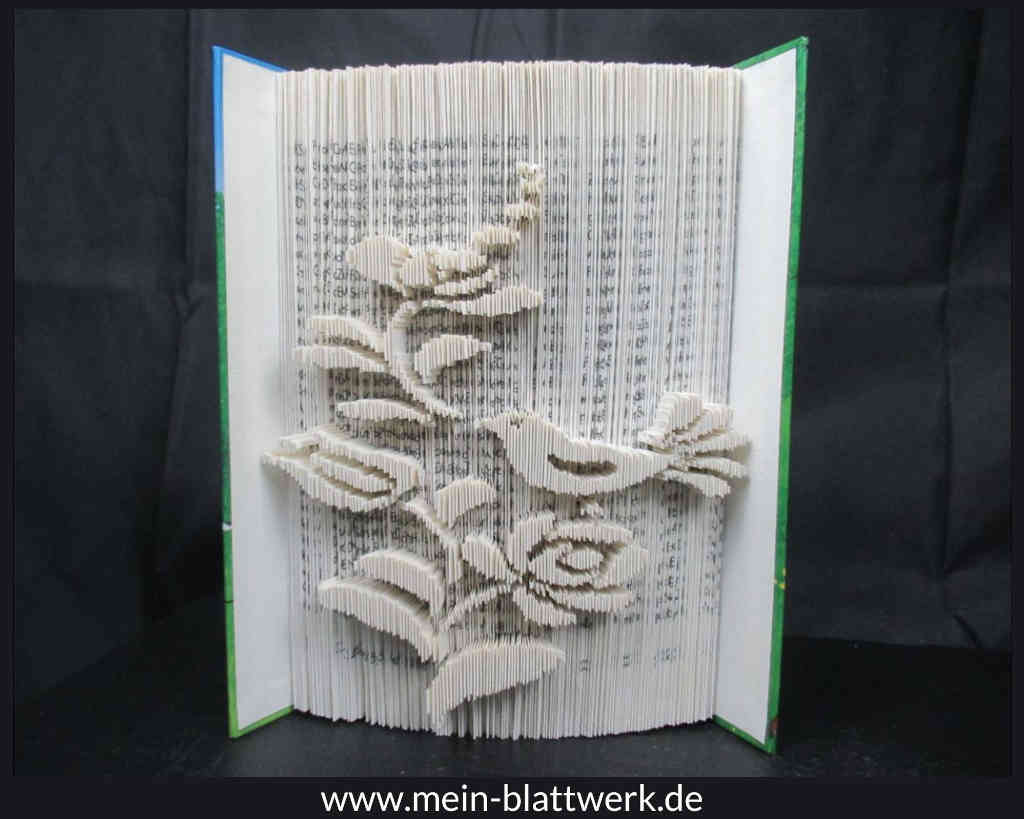 Buchkunst: Einen Vogel mit Blüte in ein Buch falten.