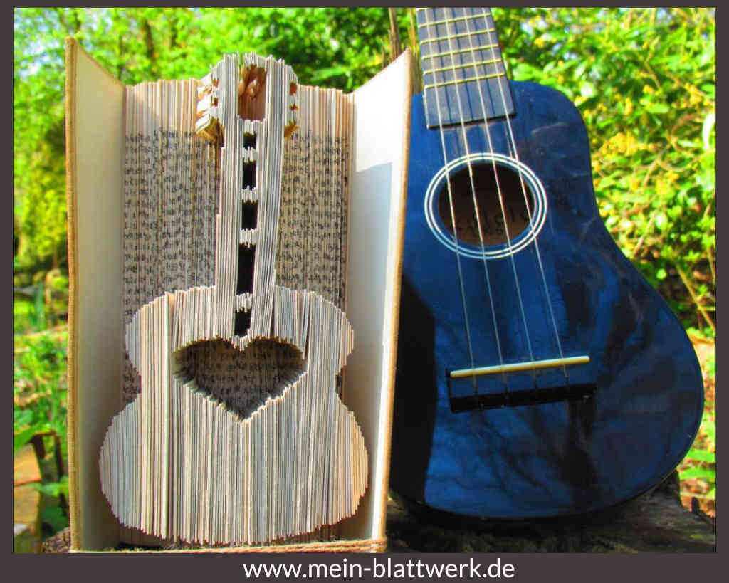 Gefaltete Gitarre in einem Buch. Mit kostenloser Anleitung und Vorlage zum Ausdrucken