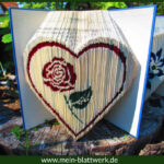 Buchfalten-Vorlage mit Farbtechnik. Eine Rose umrandet von einem Herzen in ein Buch gefaltet.